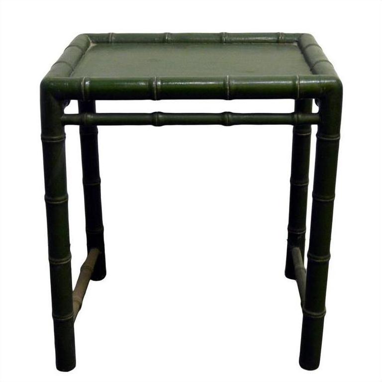 Small green bamboo side table with bamboo-inspired legs, close-up against a plain background.