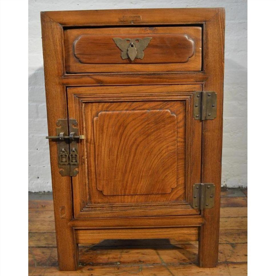 Wooden side cabinet with butterfly brass hardware, metal latch, and panel detailing in Chinese-inspired style.