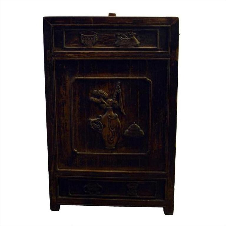 Dark wood carved side cabinet with ornate designs and a musician figure on the front panel, studio setting.