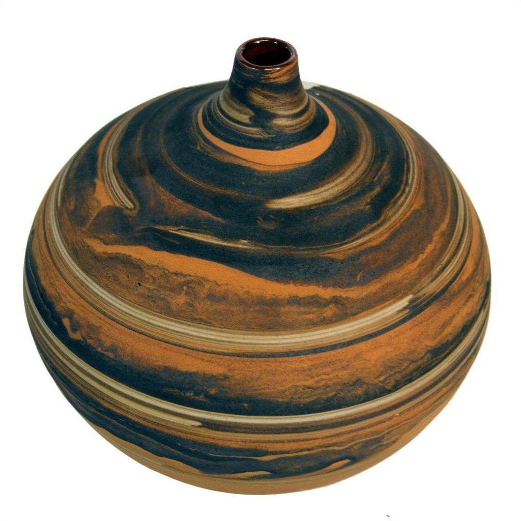 Close-up of a small round ceramic vase with orange and black marbled surface and a narrow neck.