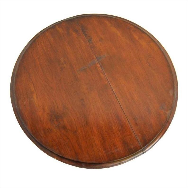 Round acacia wood table with visible center seam on white background.