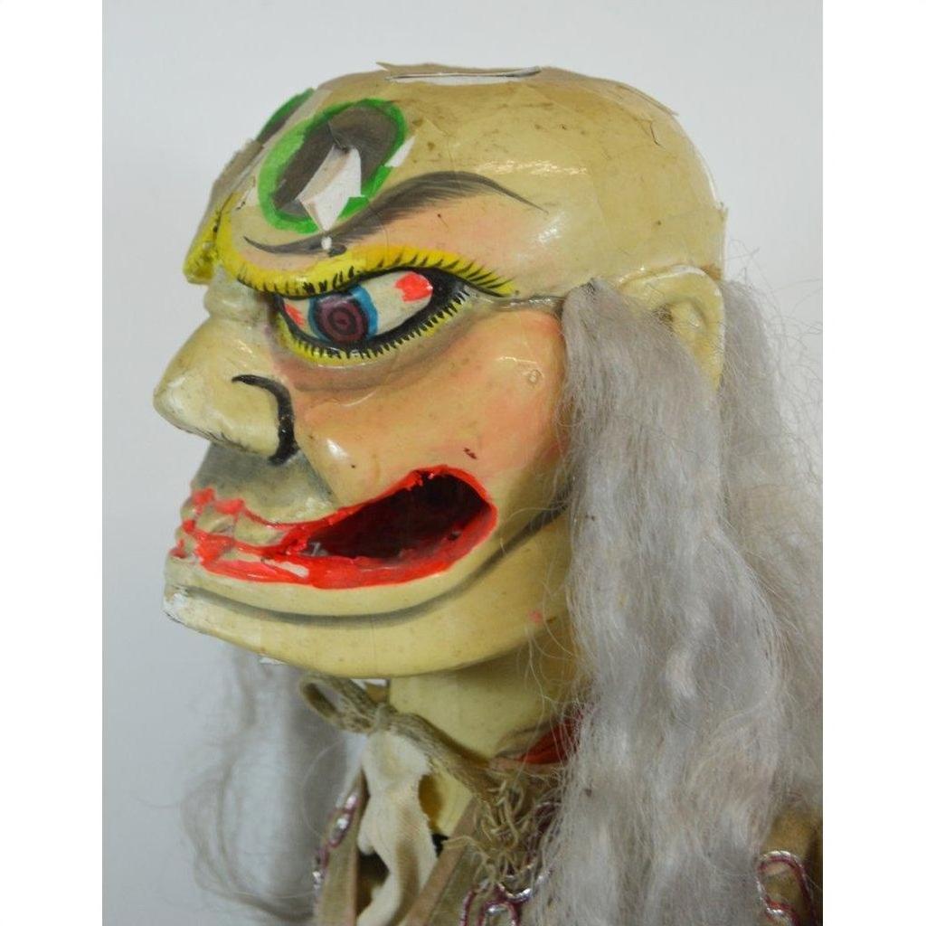 Vibrant wooden mask with exaggerated features and long gray hair in traditional colors, close-up on white background.