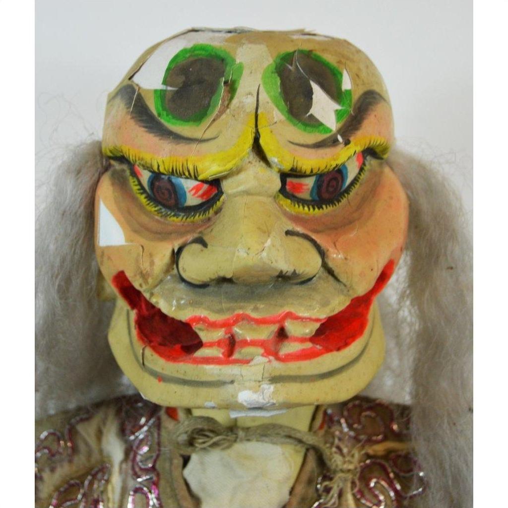 Close-up of painted Taiwan Opera Doll puppet head with bright eyes, red lips, and traditional gray hair.