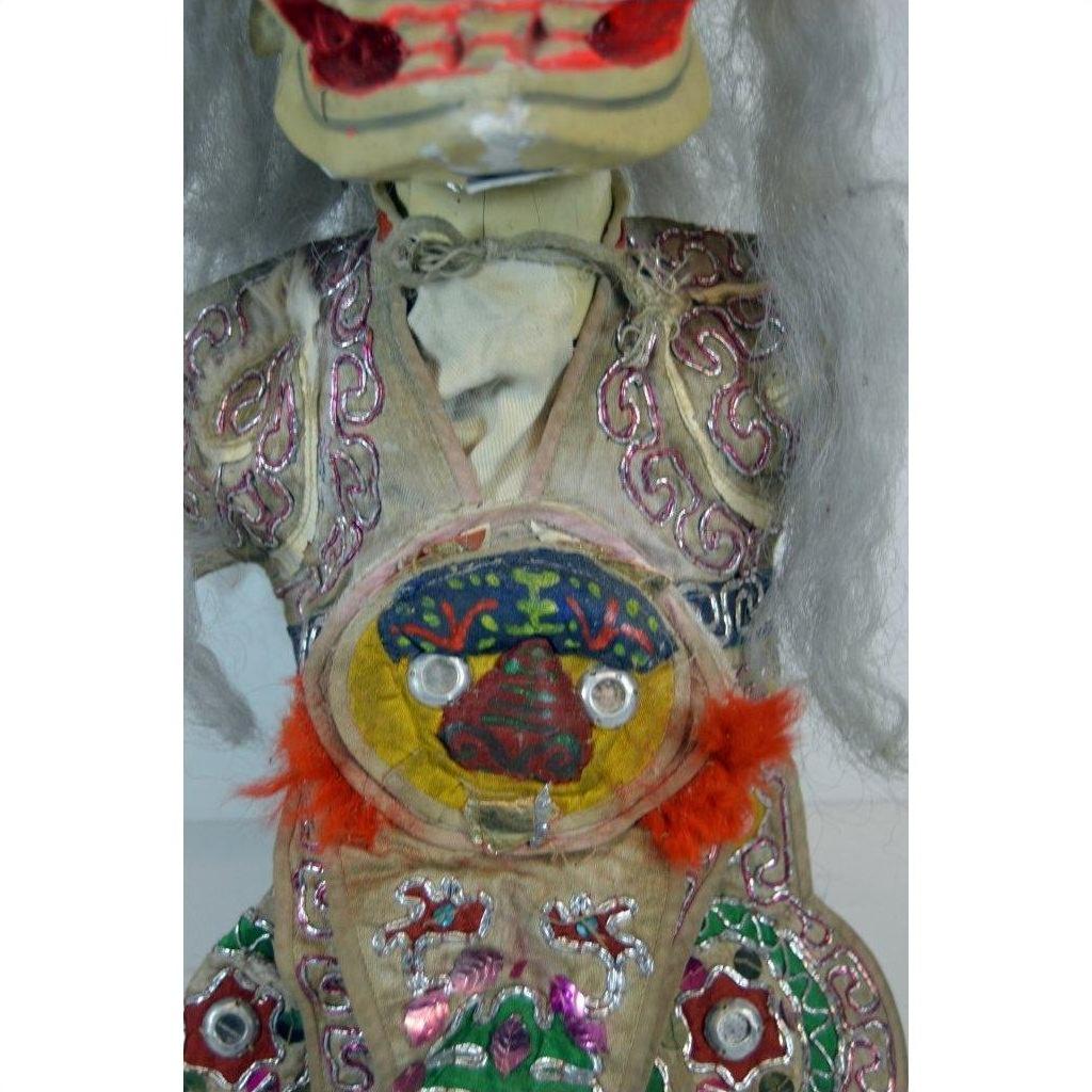 Close-up of colorful sequin and bead Taiwan Opera Doll costume with red feathers and painted chest pattern.