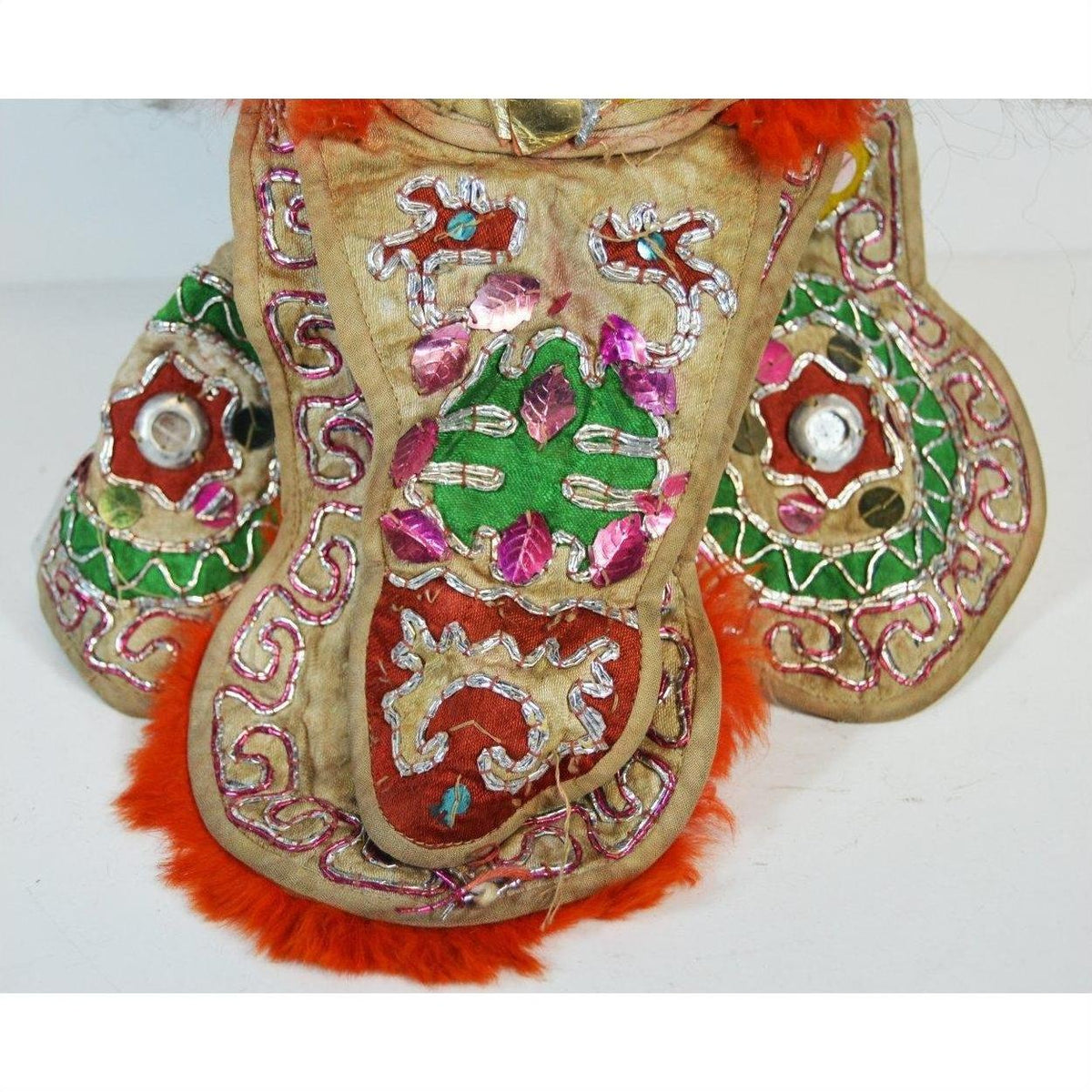 Close-up of Taiwan Opera Doll with gold fabric, colorful embroidery, sequins, and vibrant orange fur trim.