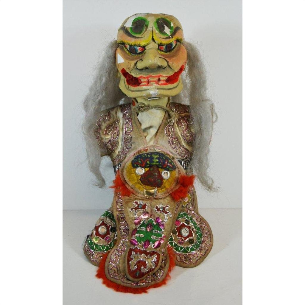 Close-up of a vibrant Taiwan Opera Doll with gray hair, large mask, bulging eyes, and embroidered costume.