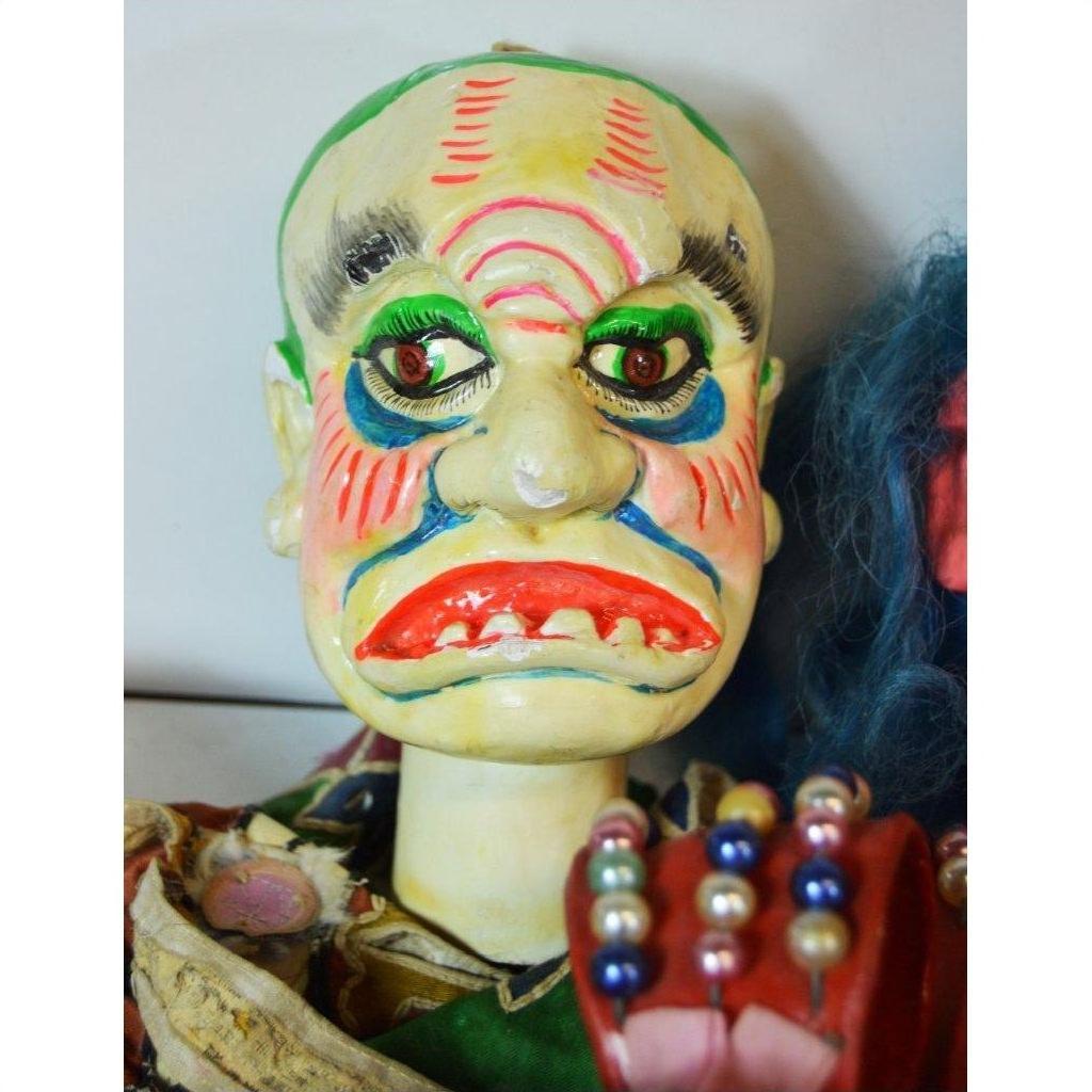 Close-up of a colorful Taiwan Opera Doll with vibrant makeup and exaggerated facial features, ceramic material.