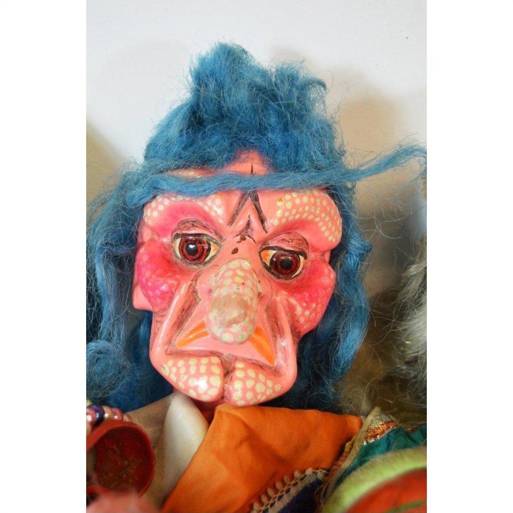 Close-up of a Taiwan Opera Doll with a pink wrinkled face, blue hair, orange outfit, and exaggerated features.