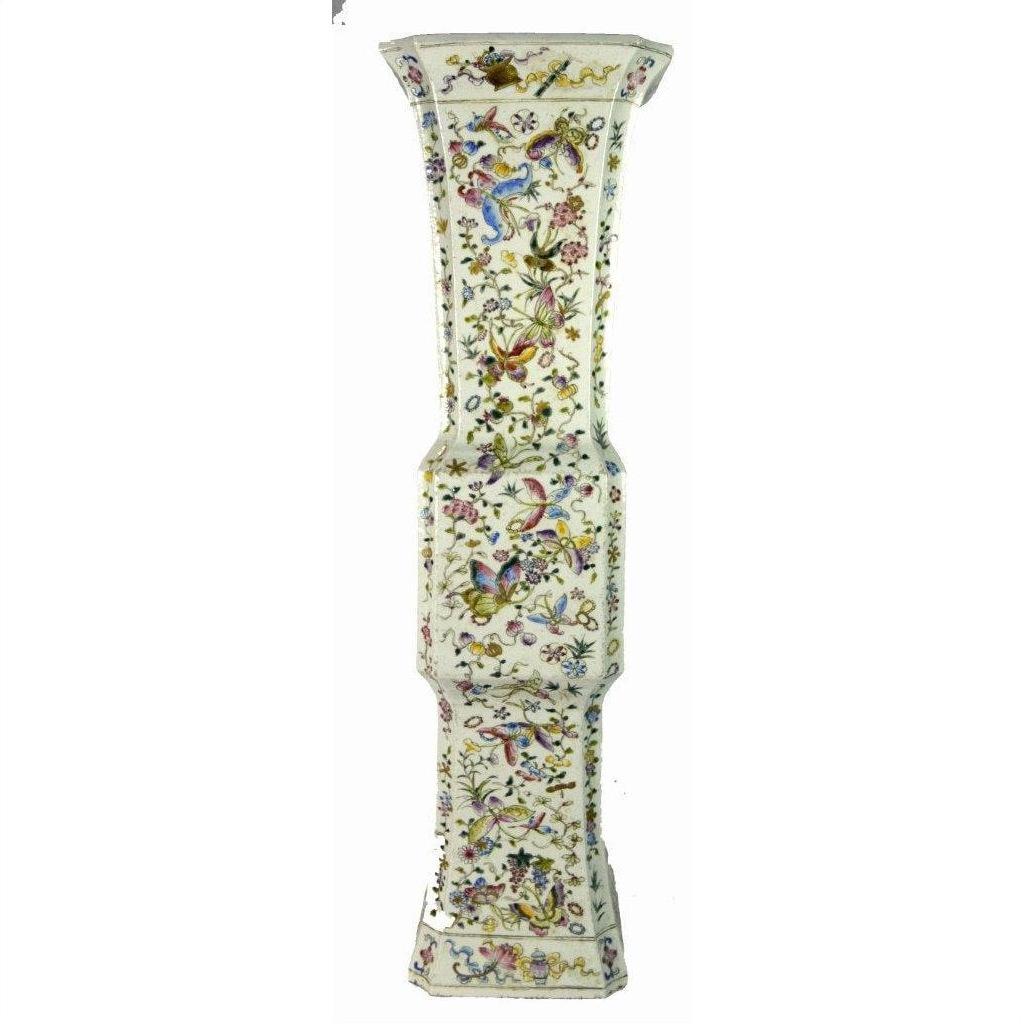 White porcelain vase with hand painted vibrant florals and delicate butterflies, faceted shape, shown against a plain background.