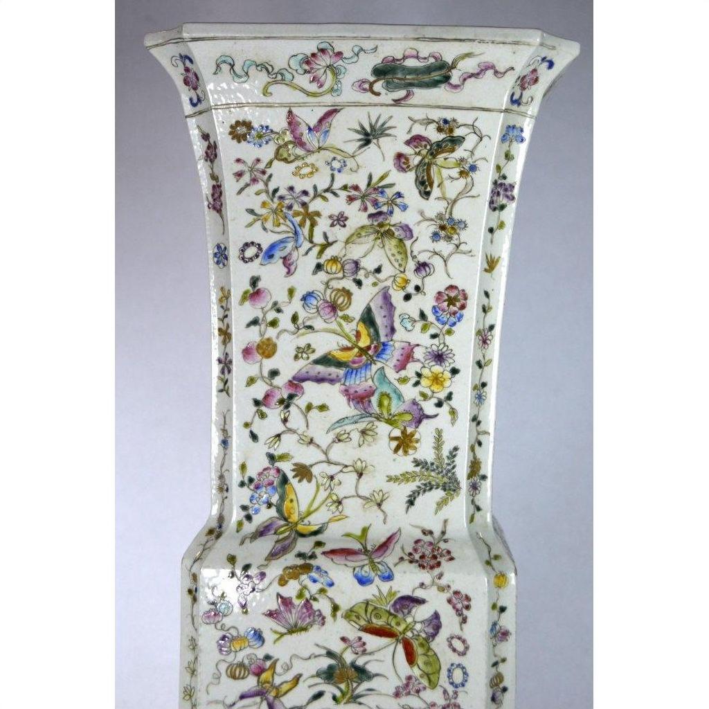 White porcelain tall Chinese vase with hand painted butterflies and colorful floral designs, close-up view.