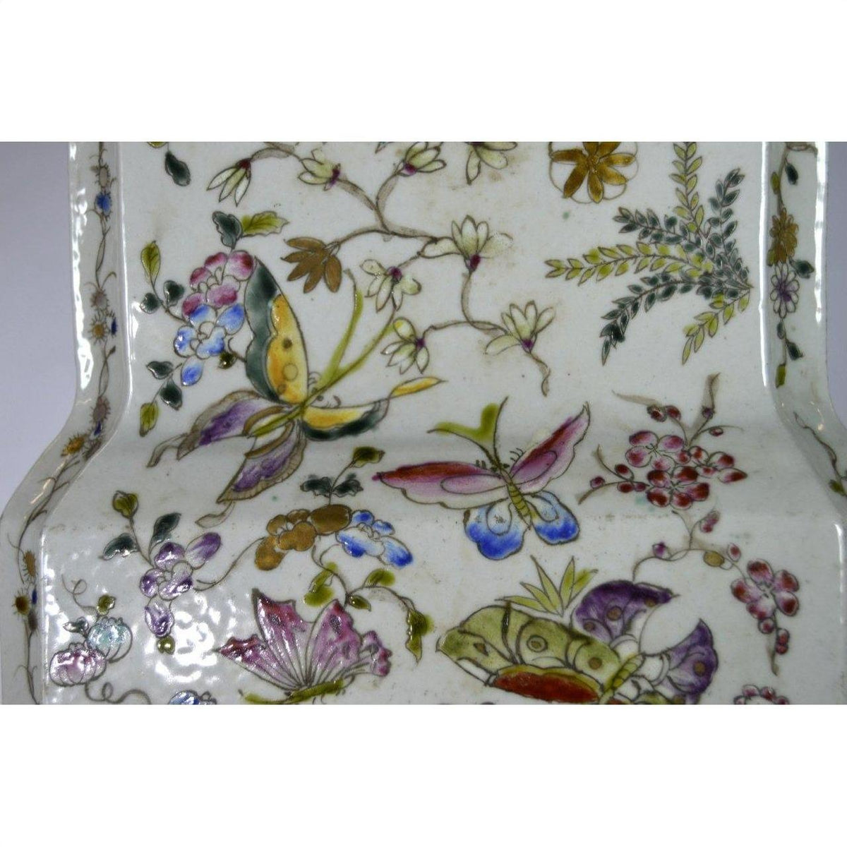 Glossy white porcelain vase with colorful hand painted butterflies and florals, tall design, studio background.