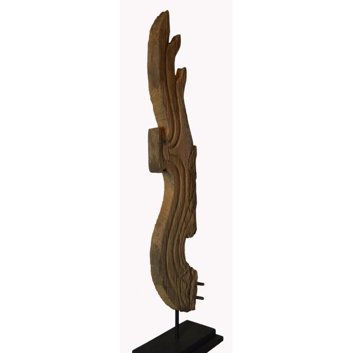 Brown carved wood Thai temple dragon sculpture, 19th century, side view, mounted on a metal base.