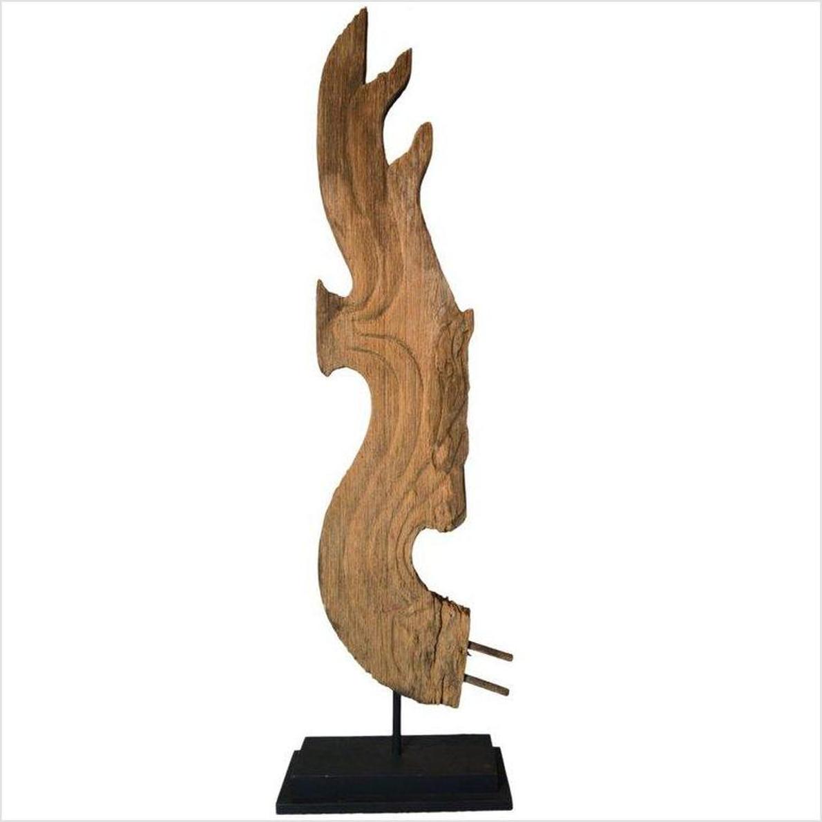 Abstract brown carved wood dragon sculpture on metal base, 19th c. Thai temple art, display mounted.