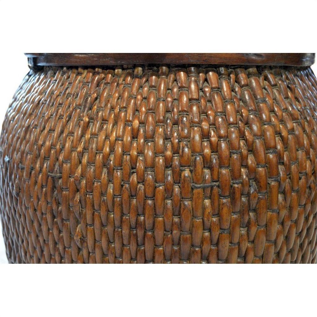 Close-up of a brown wooden Thai grain basket showing woven texture, curved surface, and intricate decorative pattern.