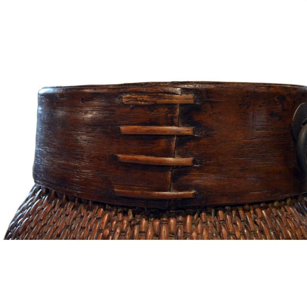 Close-up of natural brown Thai grain basket with wide dark wooden rim and three wooden pegs.