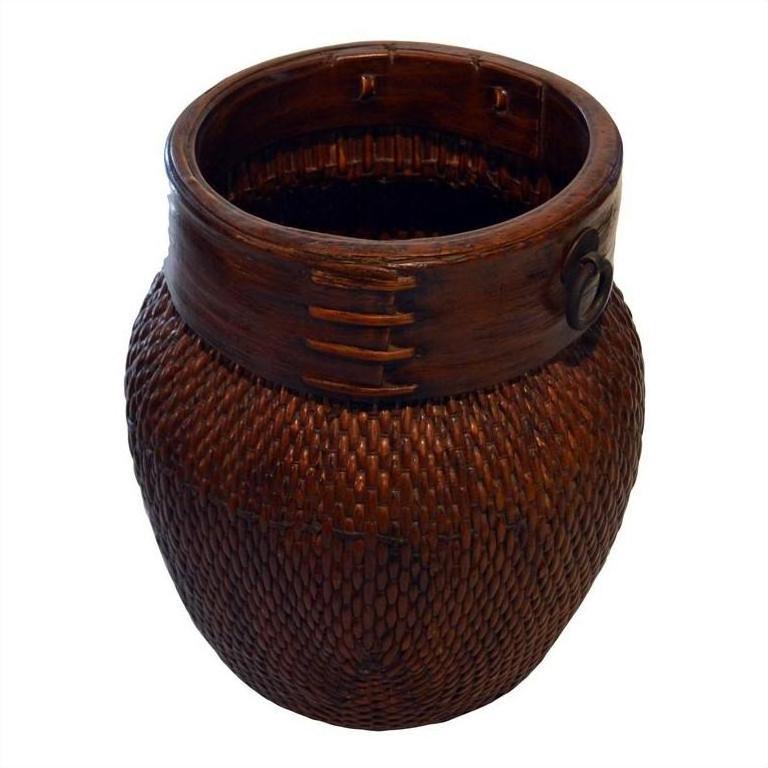 Close-up of large brown wicker Thai grain basket with smooth wooden rim and decorative stitching.