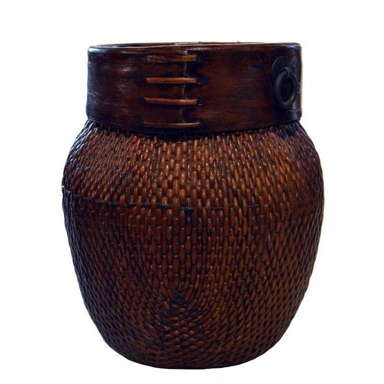 Close-up of natural woven bamboo Thai grain basket with dark wooden rim and decorative stitching, isolated on white background.