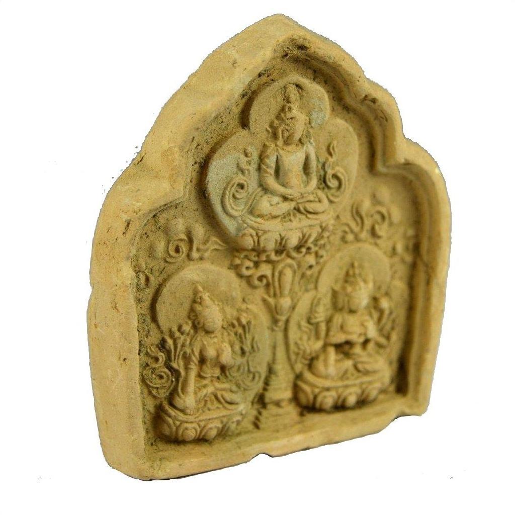 Brown terracotta miniature Thai shrine with ornate relief, featuring three seated Buddhist figures, close-up view.