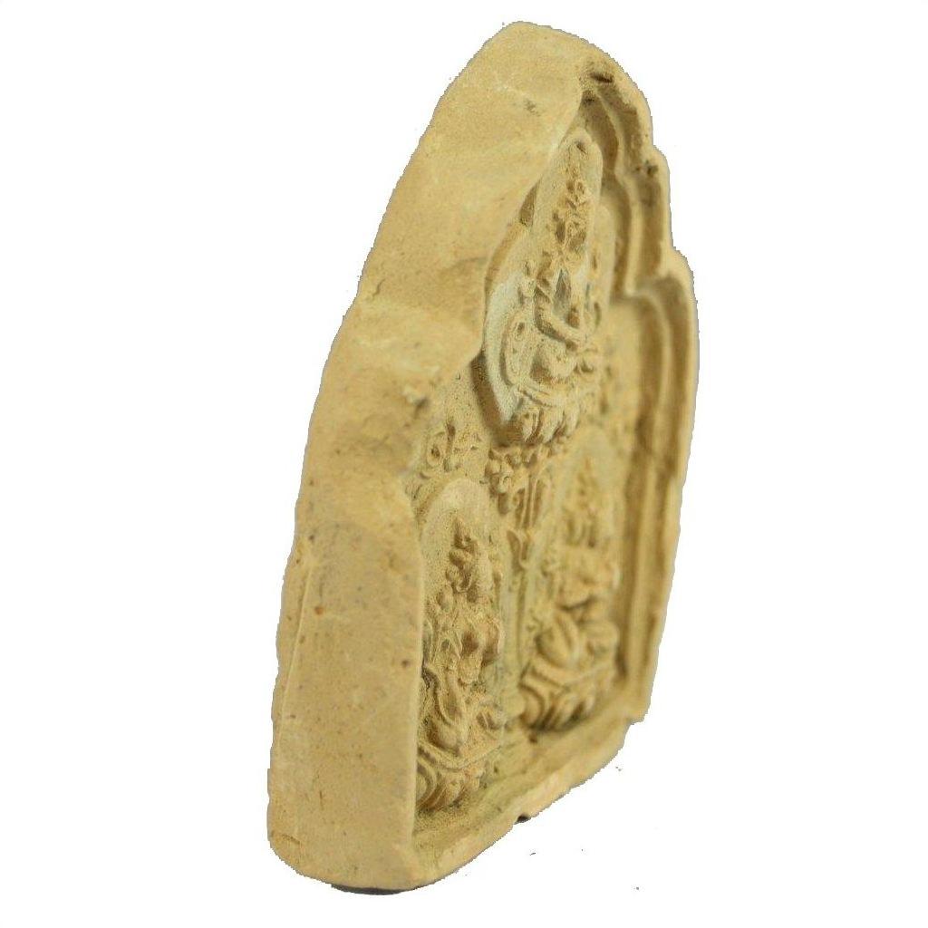 Side view of a beige stone tablet with carved religious figures, resembling a Thai miniature terracotta shrine.
