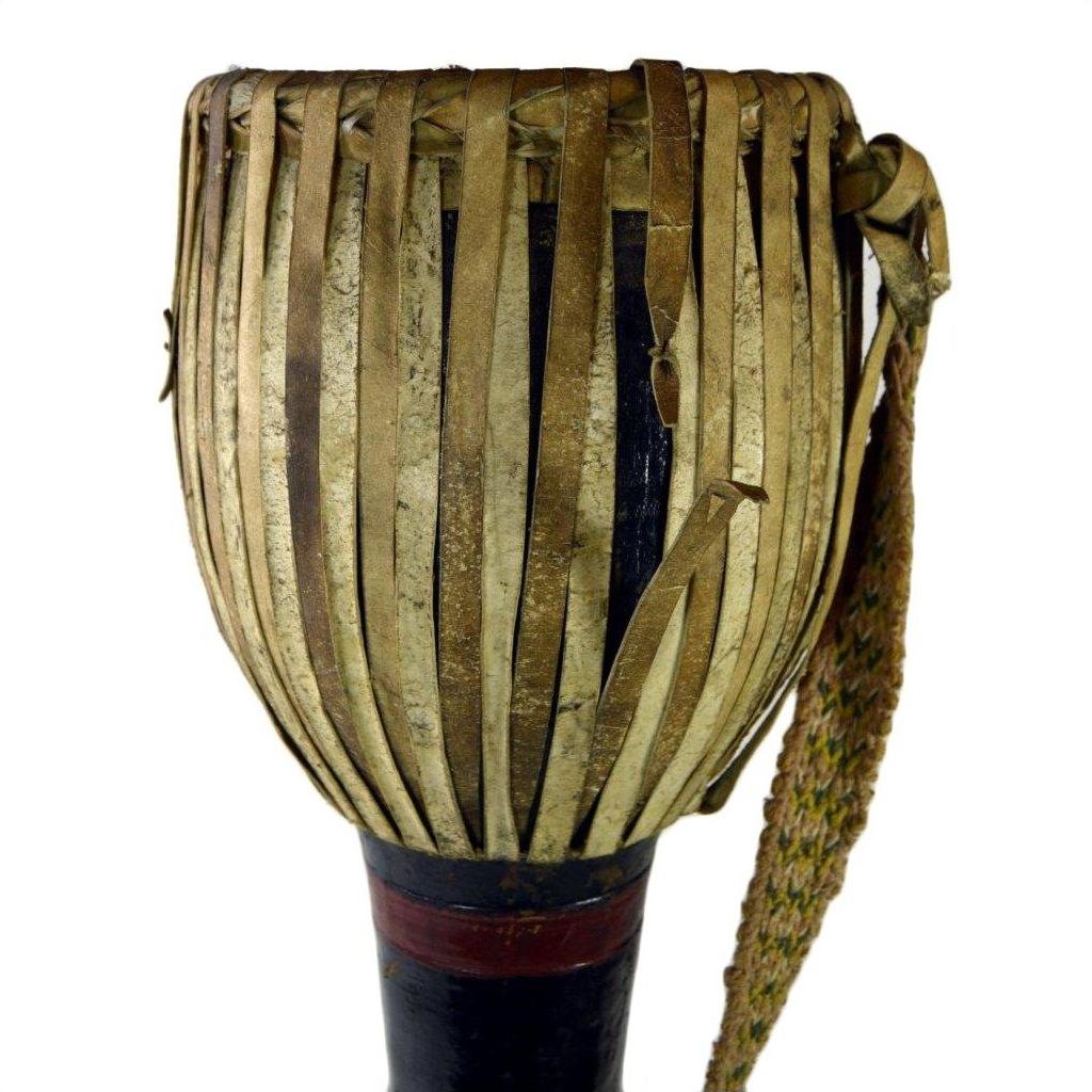 Close-up of a brown leather Thai tribal bongo drum with vertical strips and woven carrying strap in good condition.
