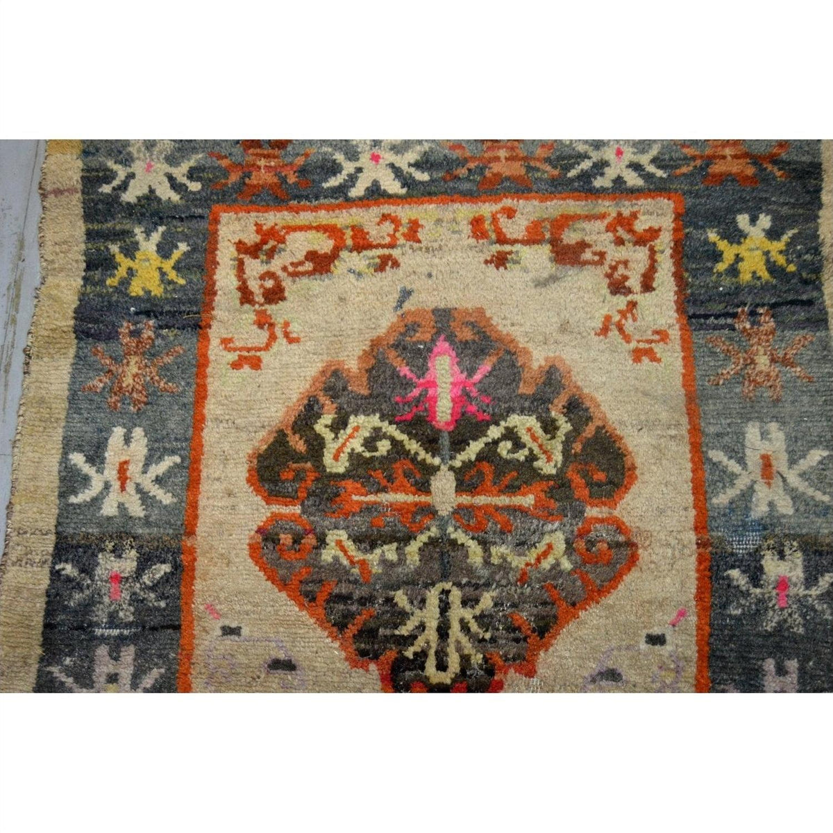 Close-up of multicolored Tibetan rug with geometric and floral patterns, vintage style, textile material, 63" x 36".