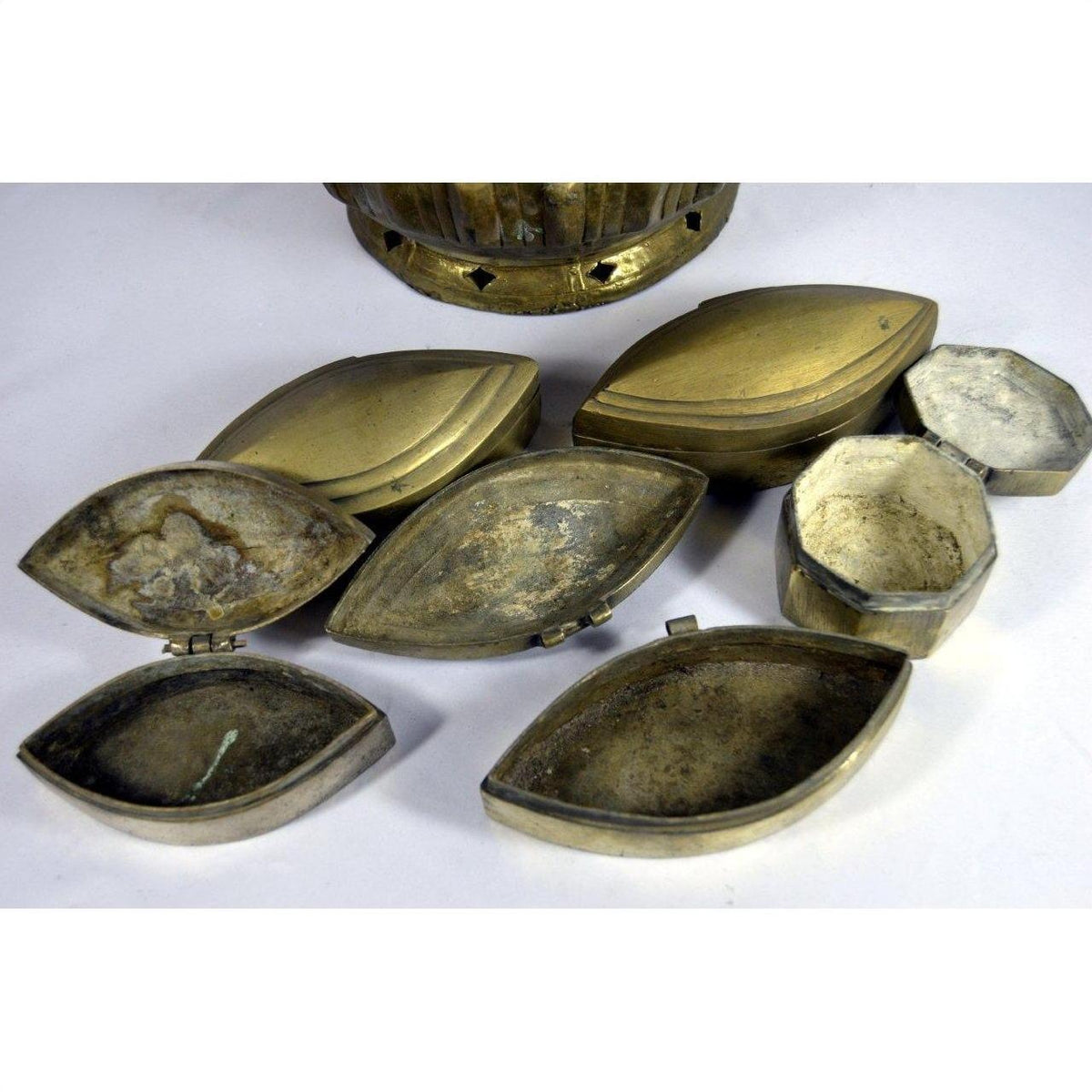 Vintage brass tiered betel nut box open on white surface, showing detailed metal craftsmanship.