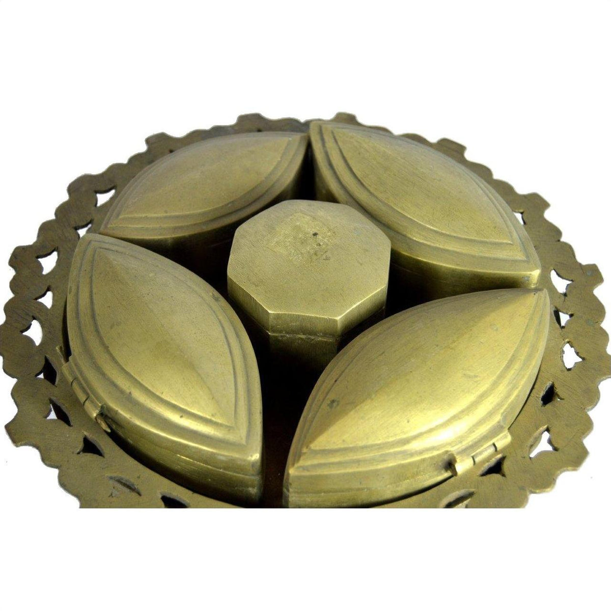Brass tiered betel nut box with four petal-shaped compartments and a central hexagonal lid, close-up view.