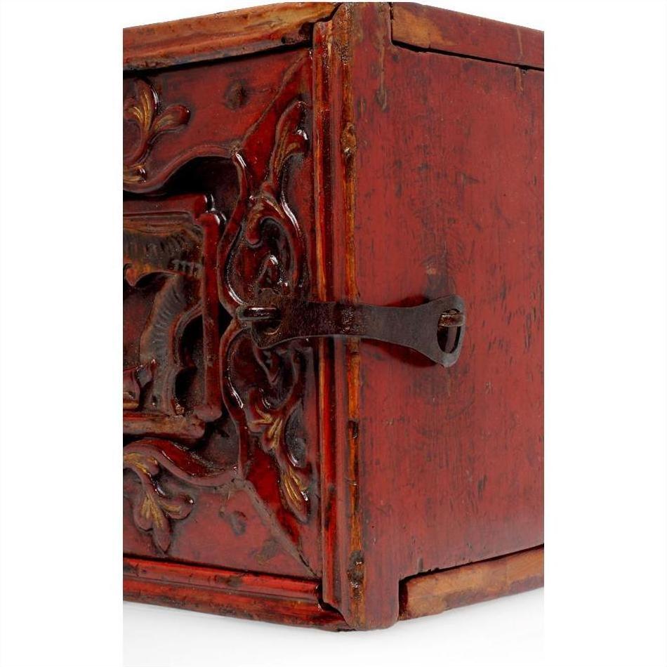 Close-up of brown wooden treasure box with raised decoration and metal latch on the front.