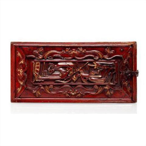 Reddish-brown hand-carved wooden treasure box with raised floral and animal motifs, close-up view.