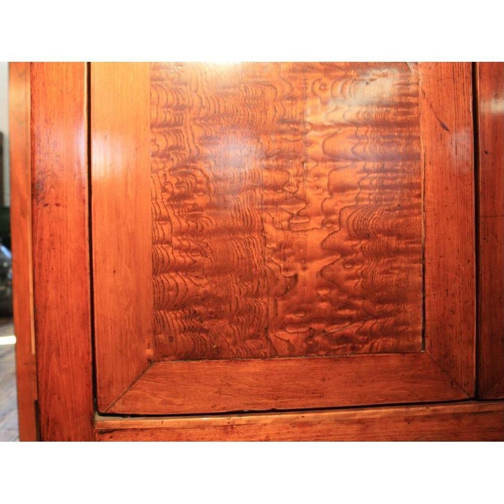 Close-up of brown burl wood cabinet door with unique grain pattern and rectangular frame.