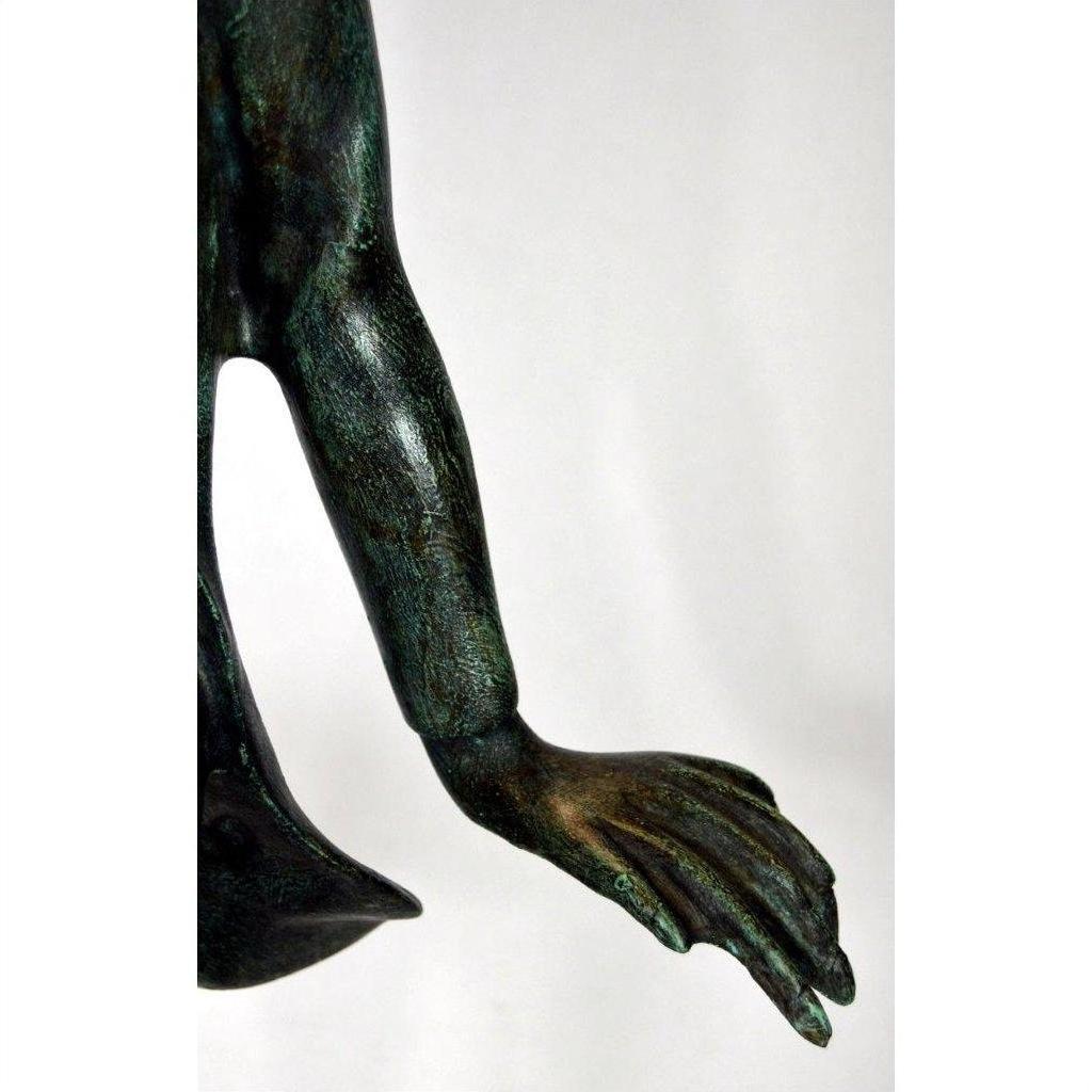 Close-up of green bronze frog statue arm and hand, white background.