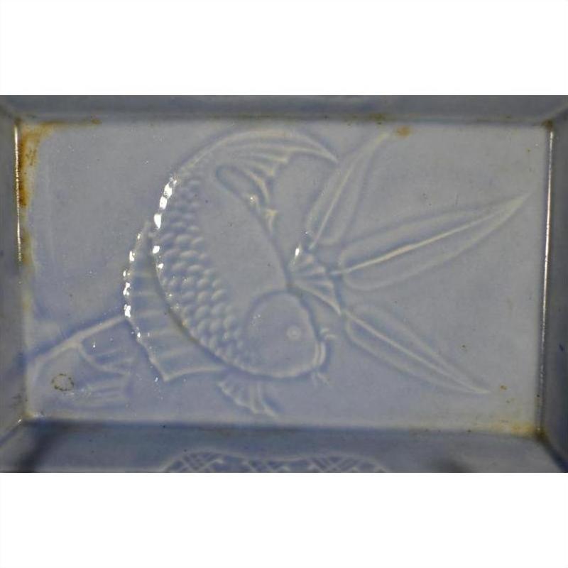Light blue porcelain dish, rectangular, with embossed fish and water plants, vintage Asian hand painted design, close-up.