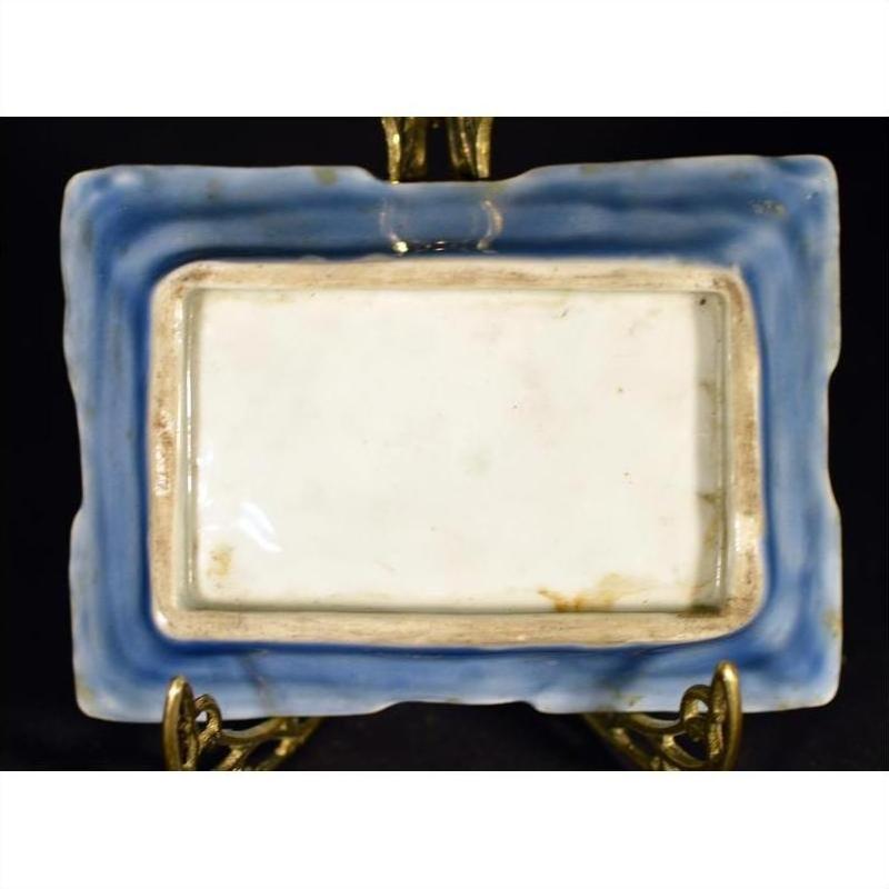 Blue porcelain dish with hand painted Asian design, vintage style, on decorative brass display stand.