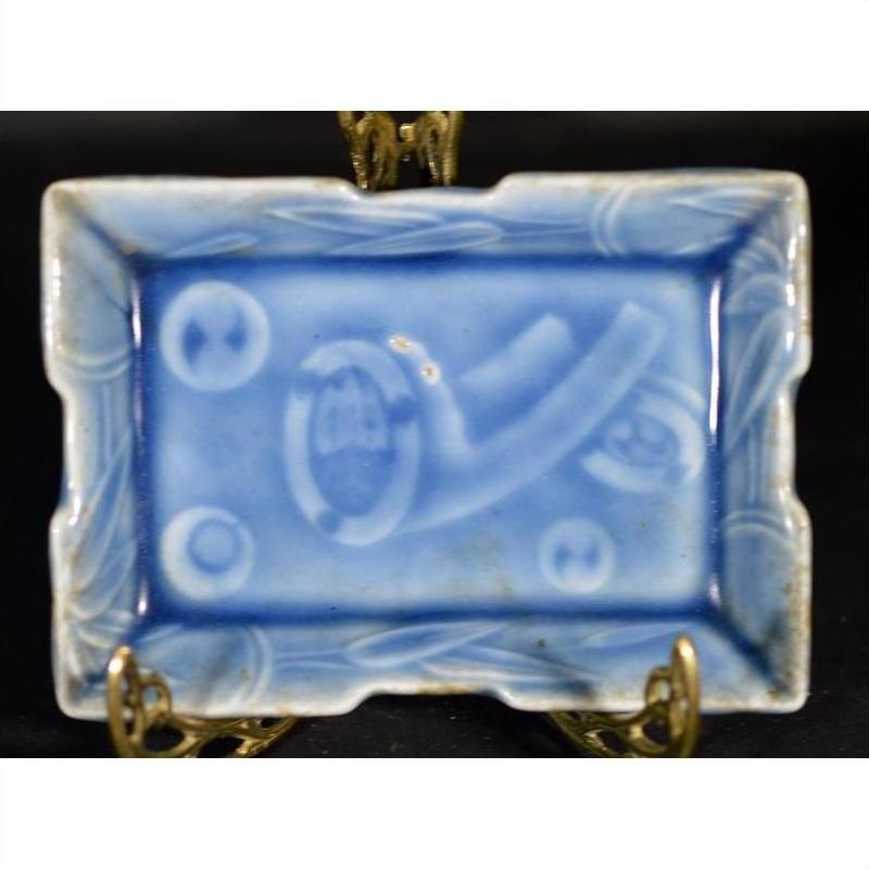 White porcelain dish with unique abstract patterns, hand painted, on a metal stand, vintage Asian style, close-up.