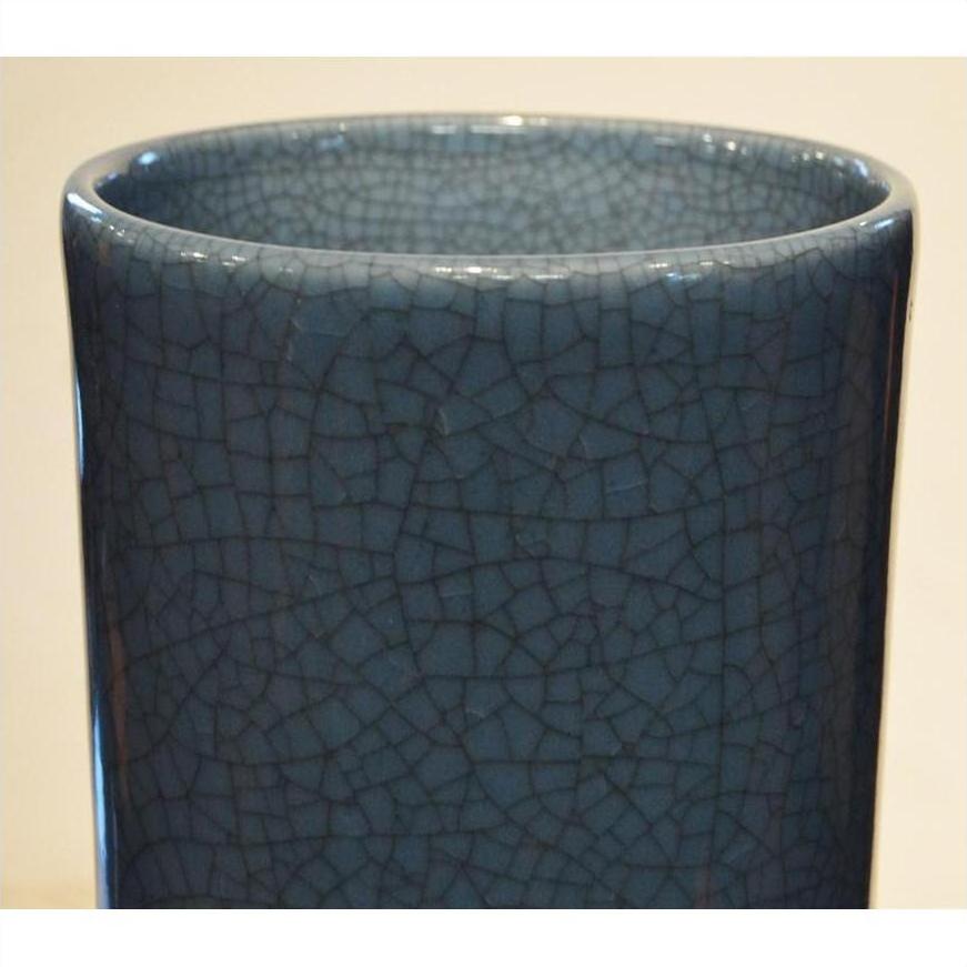 Close-up of blue crackle celadon vase with rounded rim and textured glaze.
