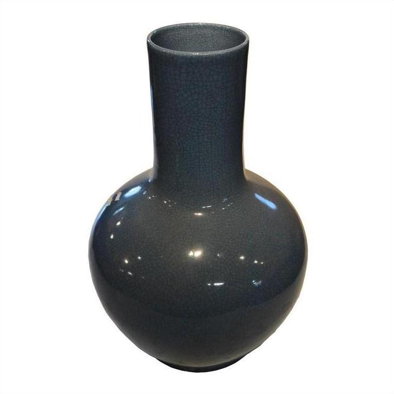 Close-up of blue crackle celadon vase with glossy hand-glazed finish and tall, narrow neck.