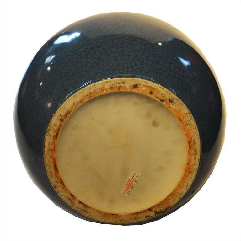 Close-up of blue crackle celadon ceramic vase base with textured glaze and red text label.