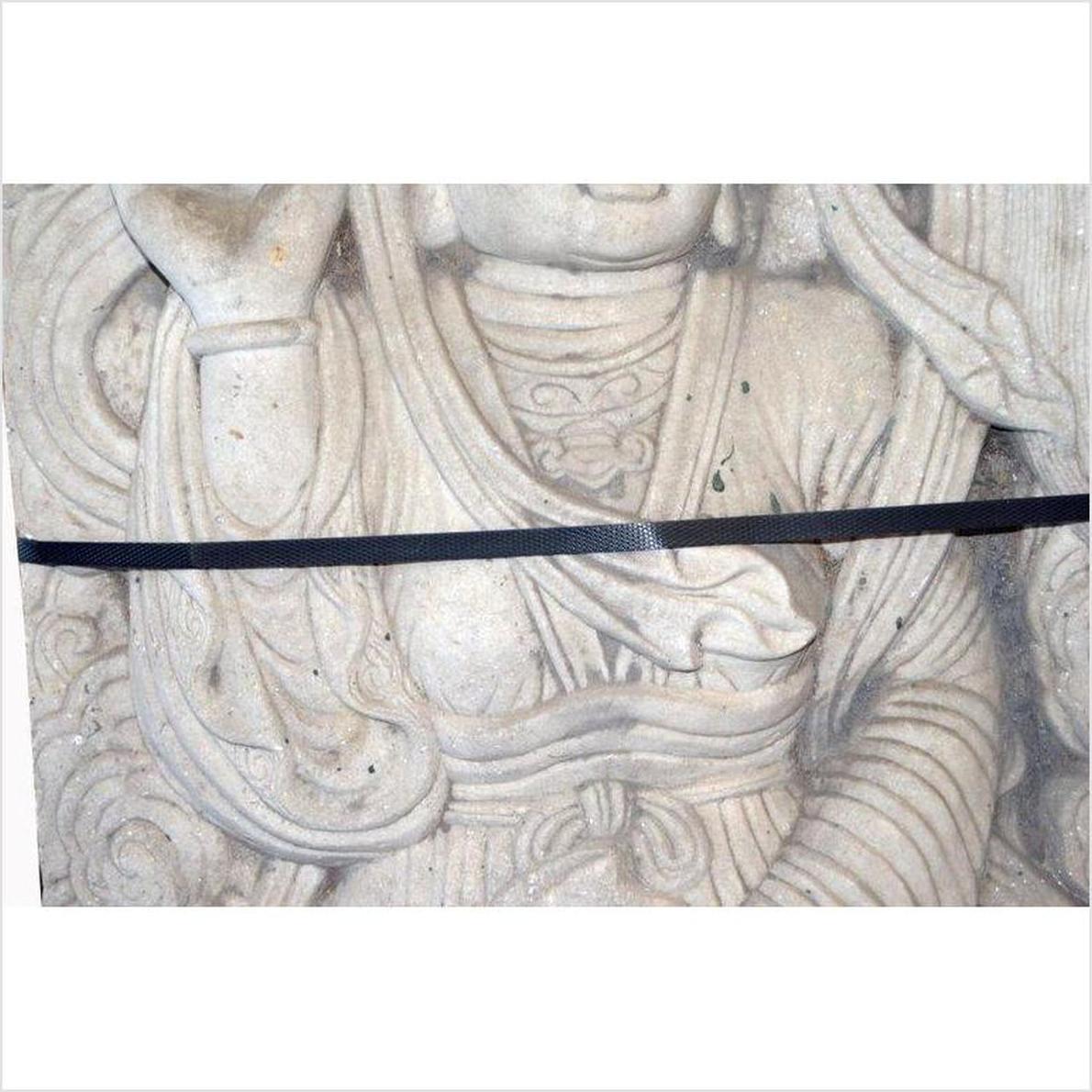 Close-up of white stone Bodhisattva sculpture with intricate carved robes and black strap, vintage Chinese style.