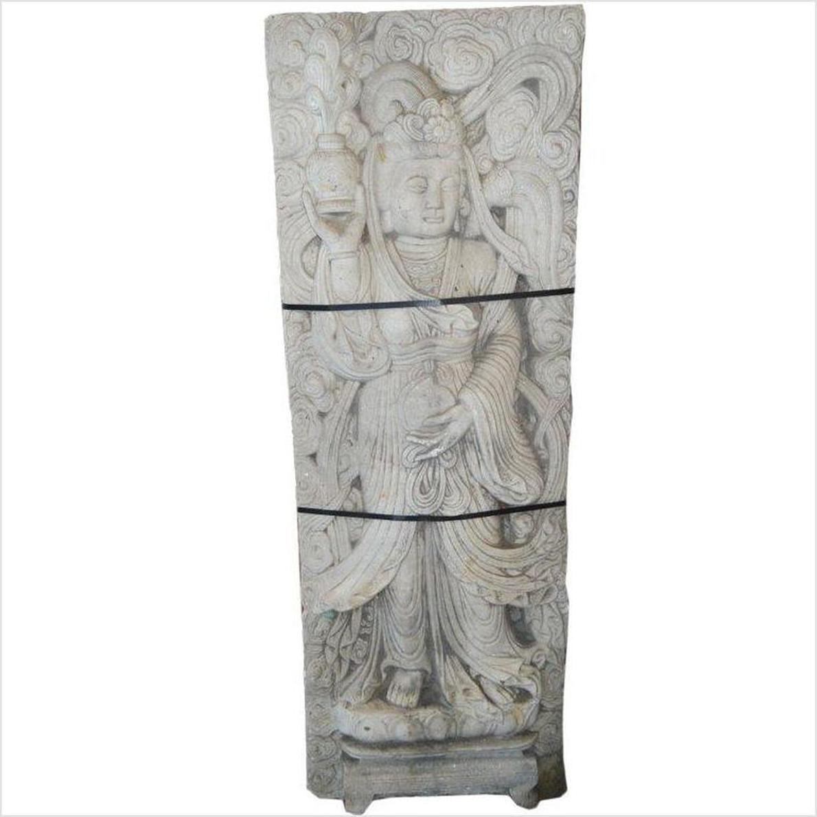 White stone Bodhisattva sculpture in flowing robes holding a vessel, surrounded by carved clouds.