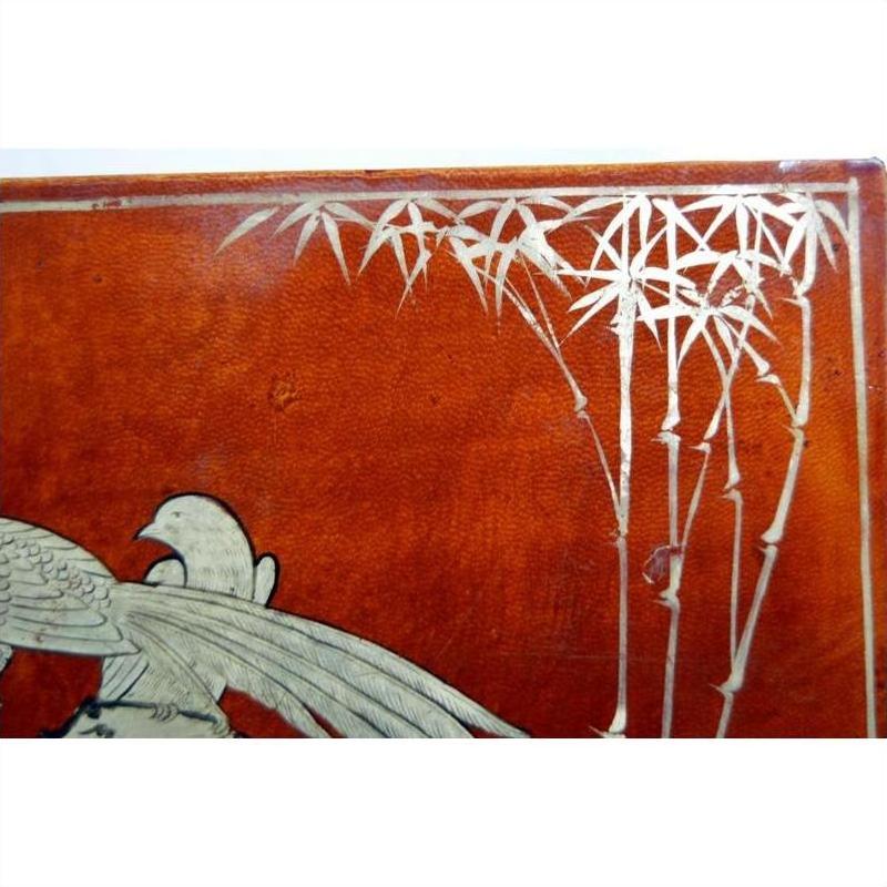 Reddish-brown lacquered vintage Chinese dowry box with hand-painted silver bird and bamboo motif, close-up view.