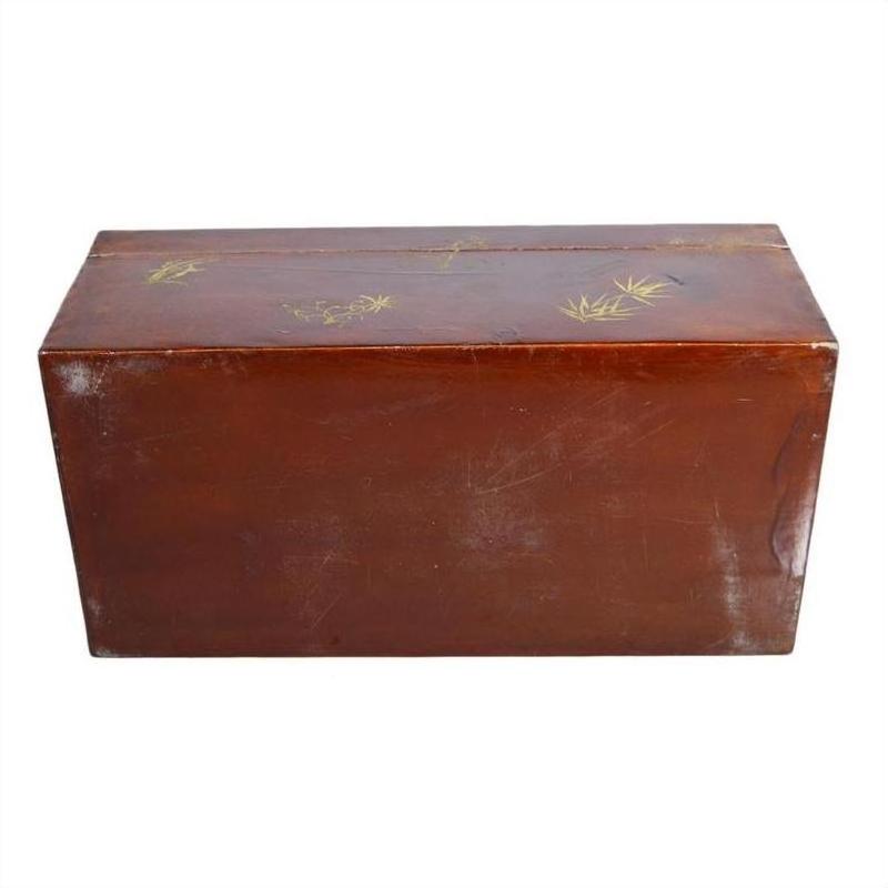 Brown lacquered rectangular box with gold floral painted lid, minor scratches, placed on a plain background.