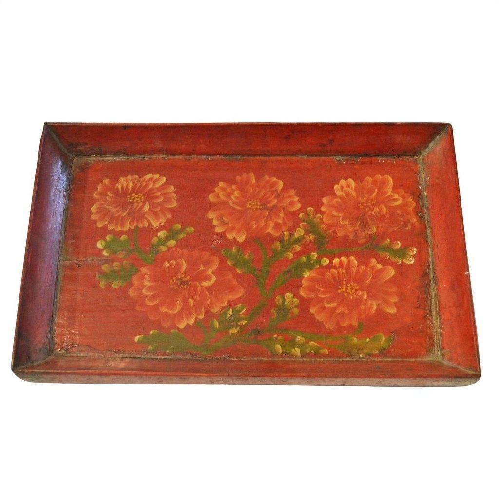 Red vintage Chinese hand painted ornate tray with orange flowers and green leaves in the center, close-up.