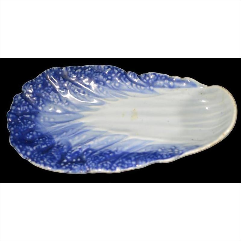Blue and white porcelain leaf-shaped dish, vintage Chinese hand-painted, close-up on black background.