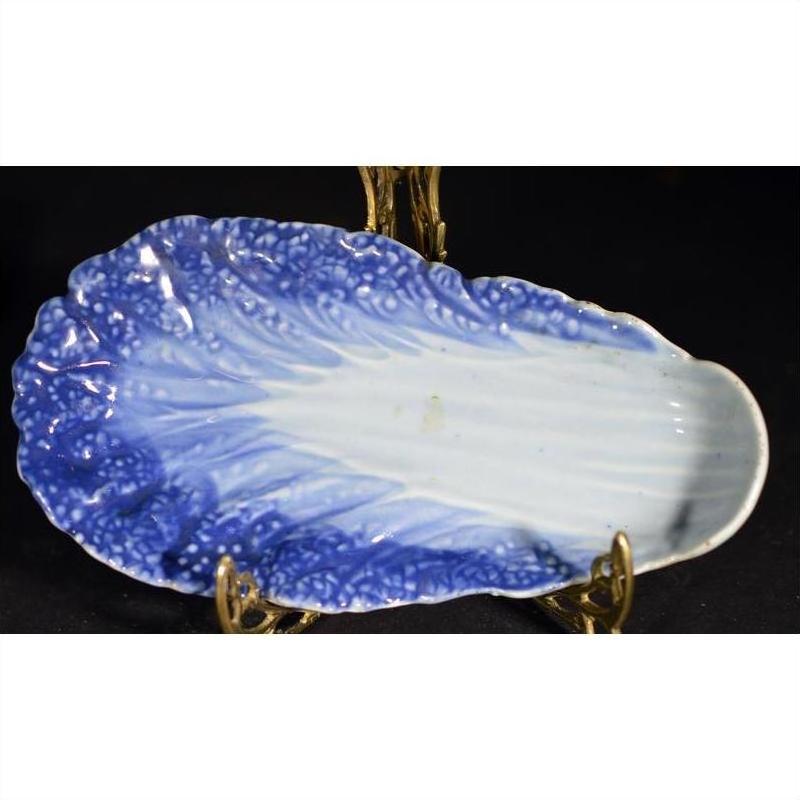 Blue and white porcelain dish, vintage Chinese, lettuce leaf-shaped, hand-painted, on metal display stand.