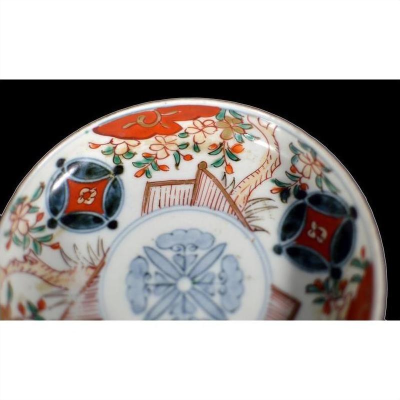 Close-up of a colorful porcelain plate with vintage Chinese hand painted floral and geometric patterns.