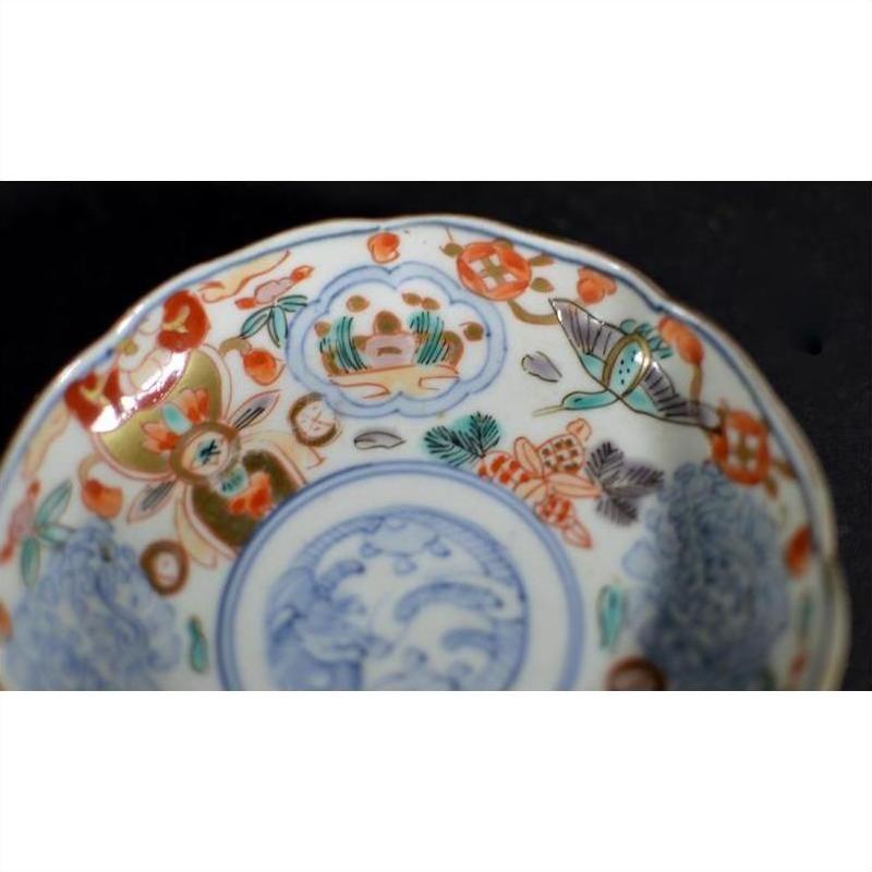 Close-up of a vintage Chinese porcelain plate with red, blue, and green hand-painted geometric and floral designs.