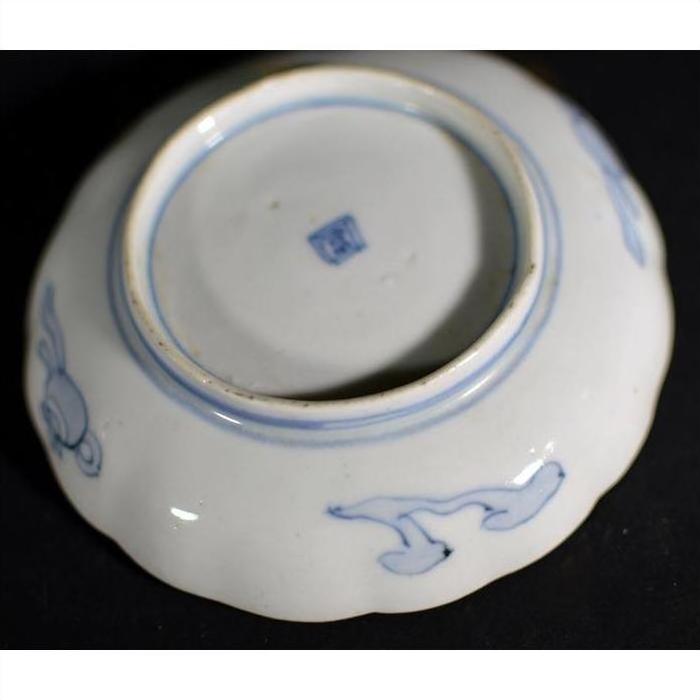 Close-up of a white porcelain plate with vintage Chinese hand painted decorative details.