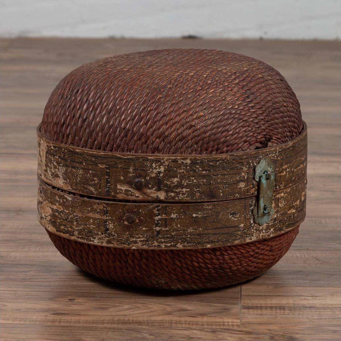 Brown rattan ottoman with wood band and weathered patina, round shape, inspired by vintage Chinese hat box.