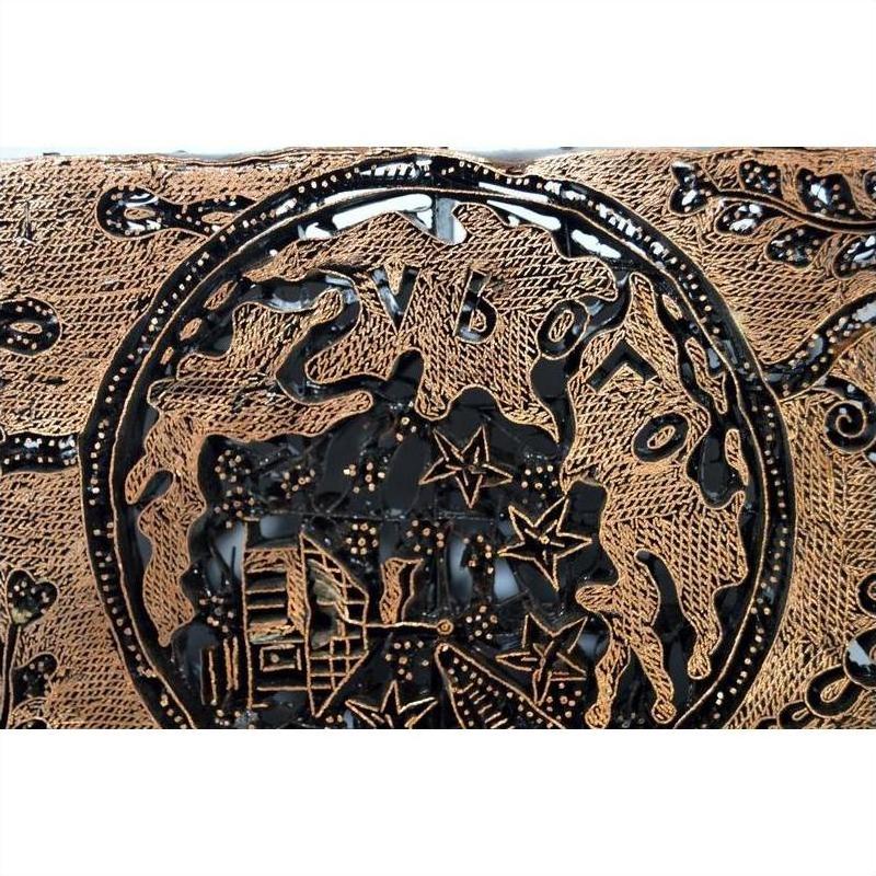 Close-up of vintage copper Batek ink block with ornate embossed star-shaped patterns.