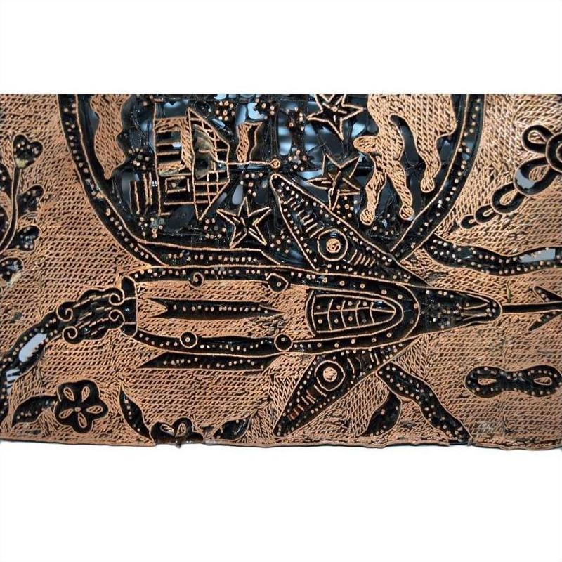 Vintage copper Batek ink block with engraved rocket, stars, planets, and house on a cosmic-themed background.